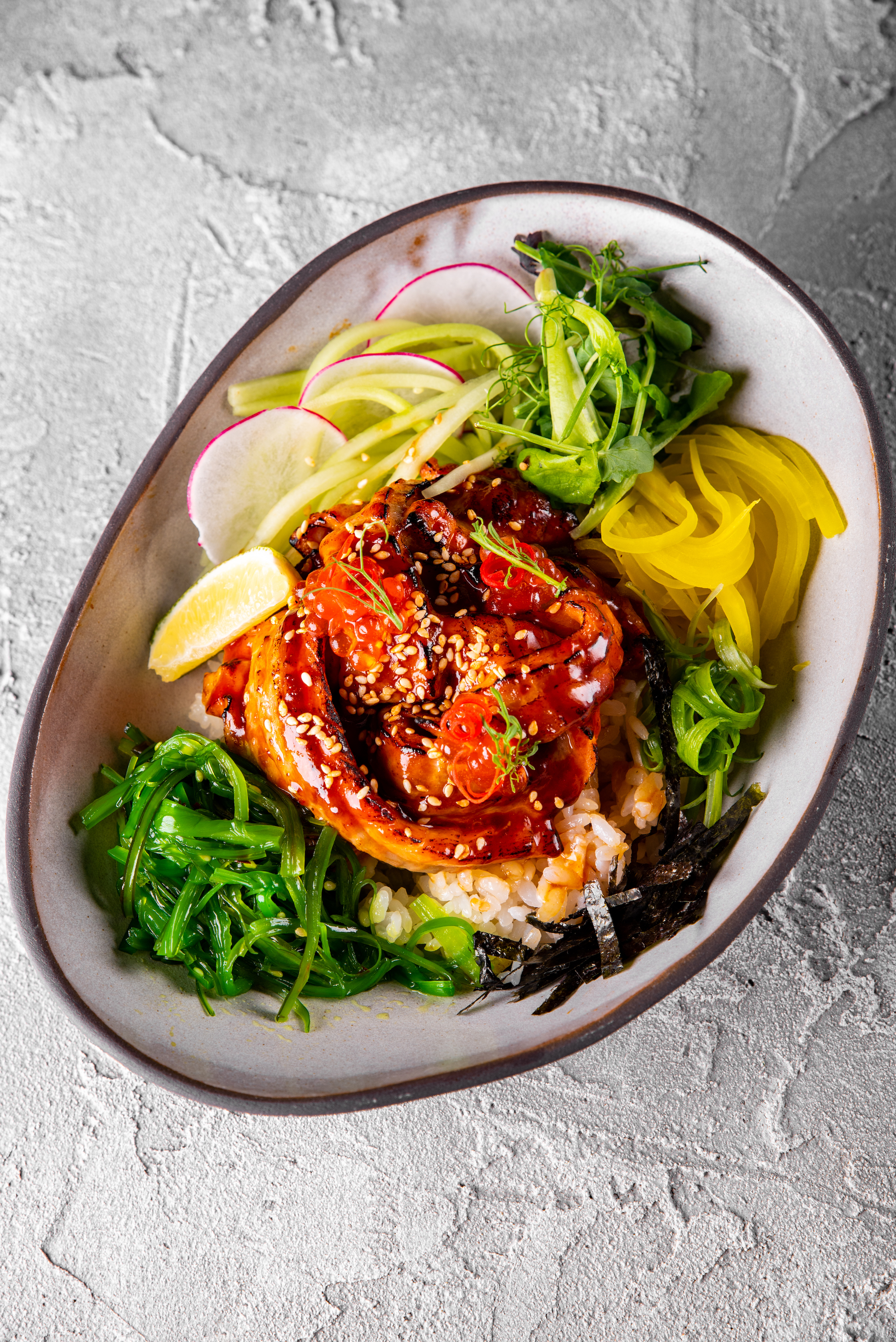 Domburi with salmon in oyster glaze with rice, chuka salad, takuan, cucumber and greens<br>310 g.